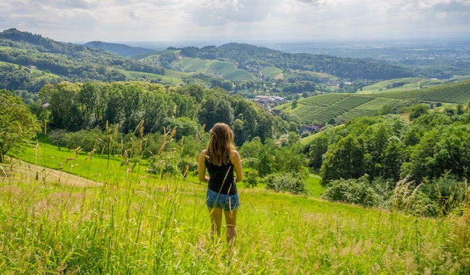Kristin Addis standing in a green field with views of rolling hills