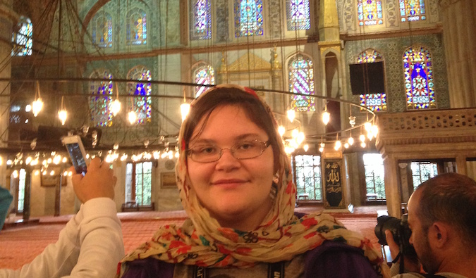 A young traveler posing inside the Blue Mosque in Istanbul, Turkey