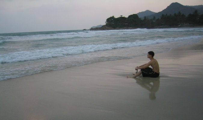 Nomadic Matt reflecting on a beach in Thailand