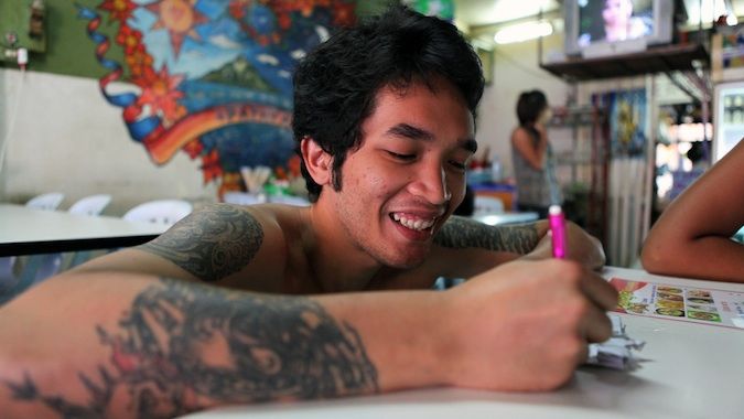 A local Thai man with tattoos at a restaurant in Thailand