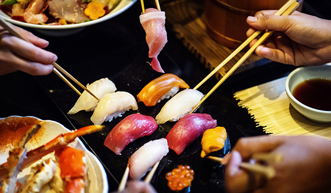 people sharing plates of sushi