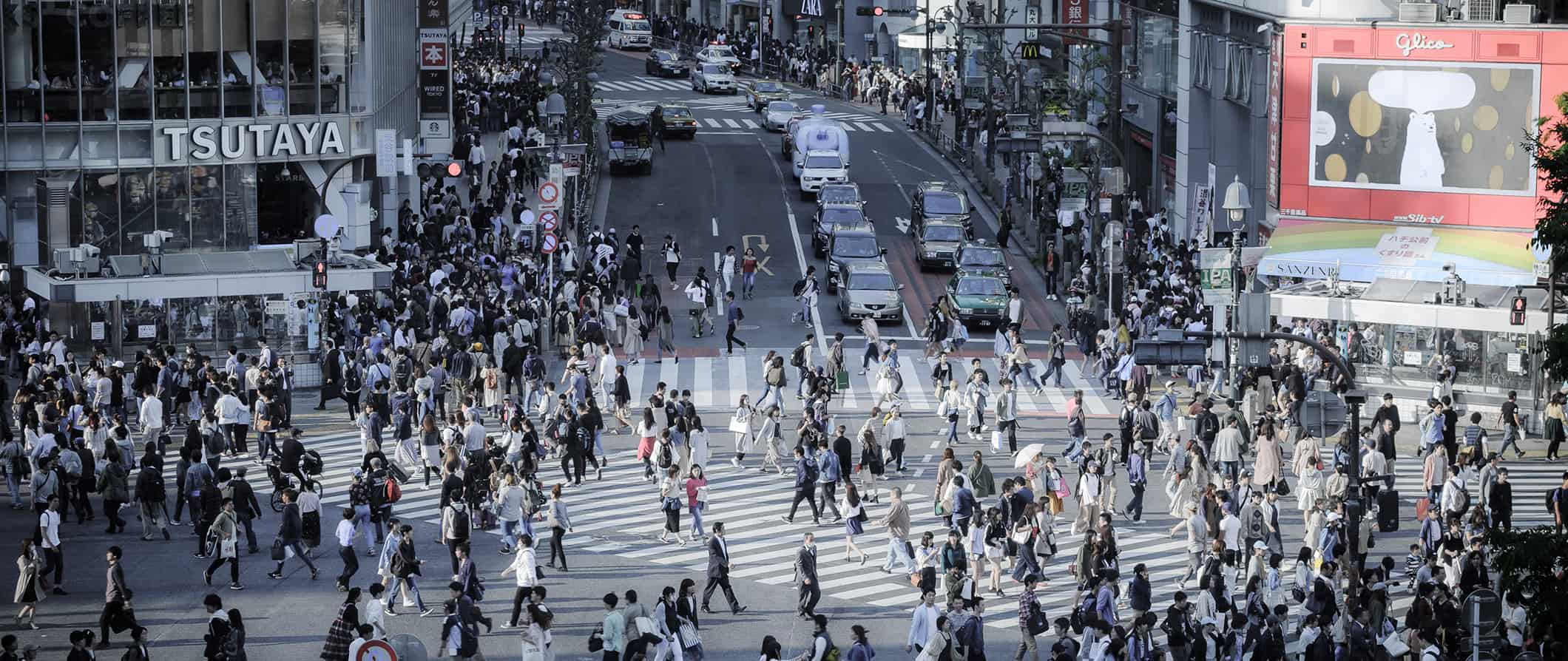 a busy intersection in Tokyo, Japan as thousands of people cross the street