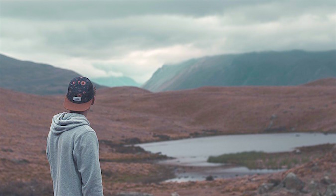 A man looking at a a valley on a cloudy day