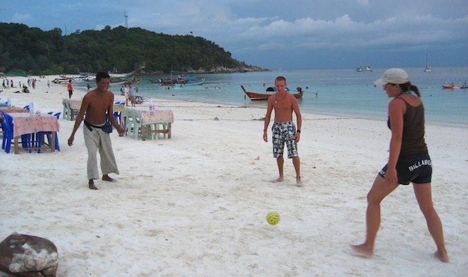 Budget backpackers playing soccer on the beach in Ko Lipe