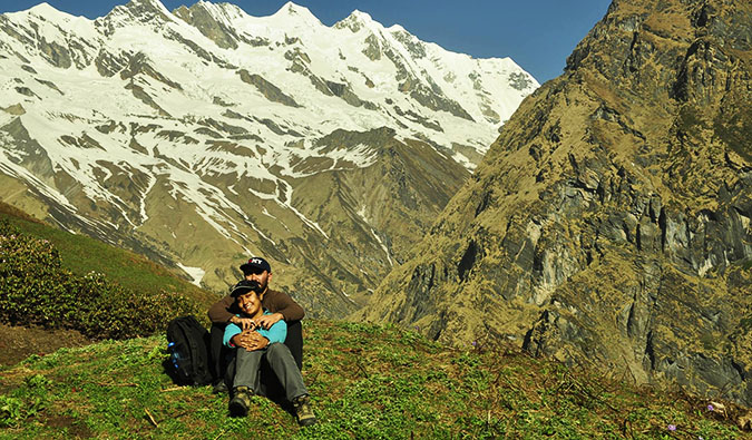 Vikram and Ishwinder from Empty Rusacks sitting together on a hill near snow-covered mountains
