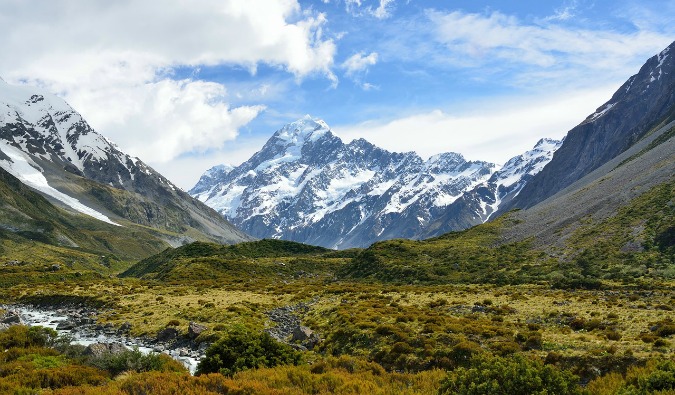 Snow-capped mountains in the background of a green valley in New Zealand