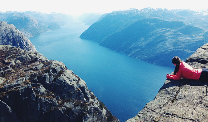 a woman looking at a fjord on a sunny day